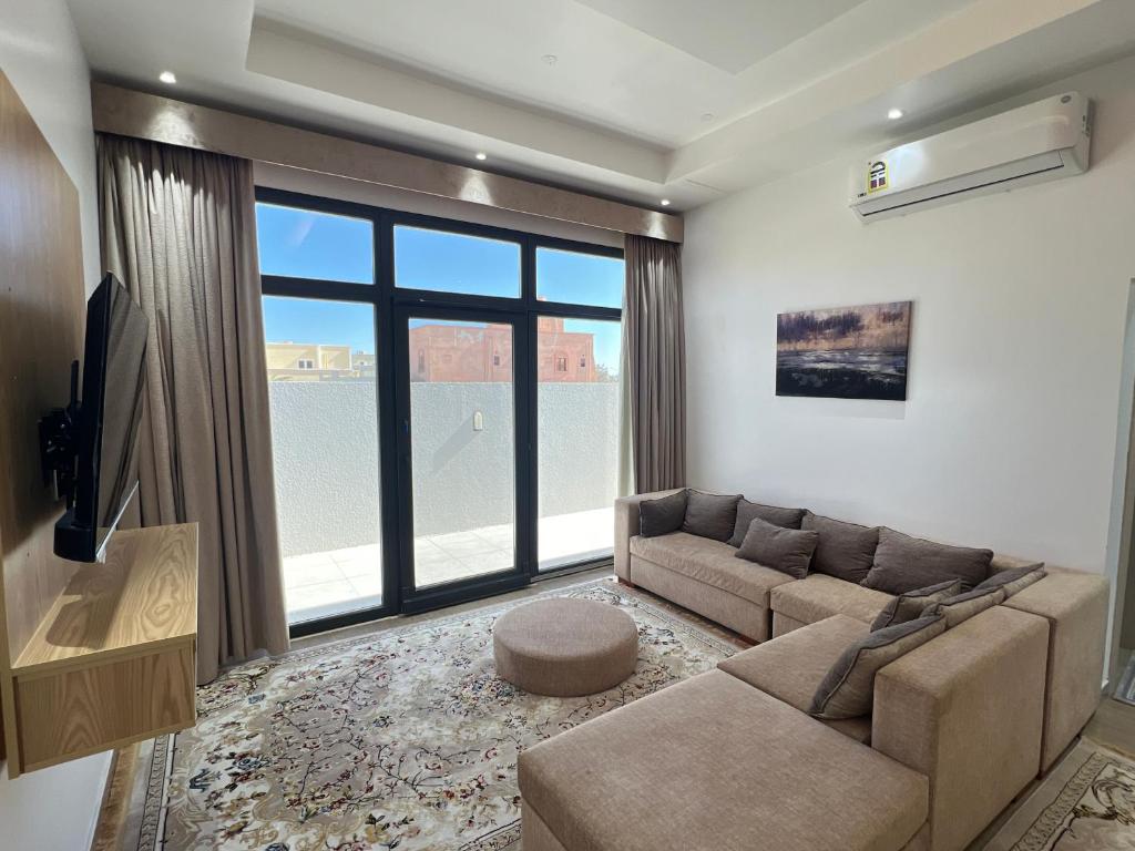 a living room with a couch and a large window at ALSALAM HOSTELS in Nizwa