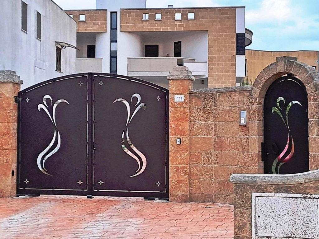 un par de puertas metálicas con pavos reales pintados en ellas en Casa Maia, en Poggiardo