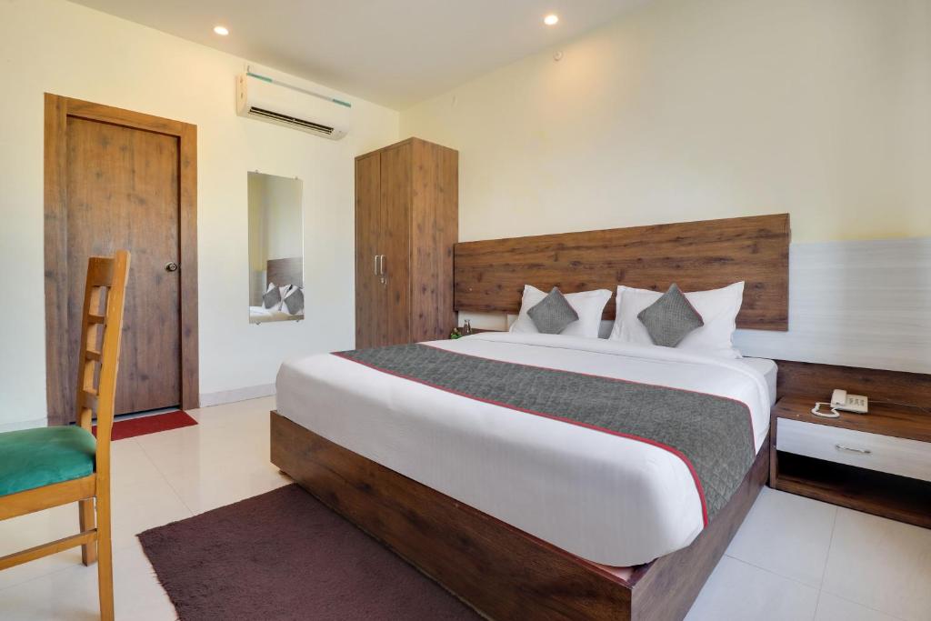 a bedroom with a large bed and a chair at Townhouse Hotel Rooftop in Rishīkesh