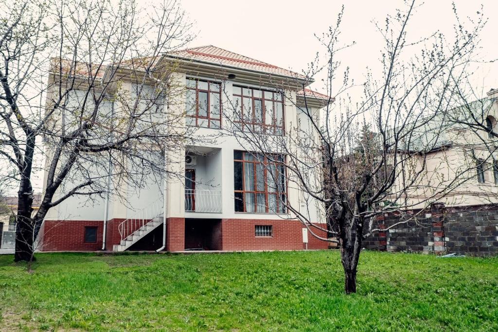 una casa con ventanas rojas y un patio verde en Green Hill en Almaty