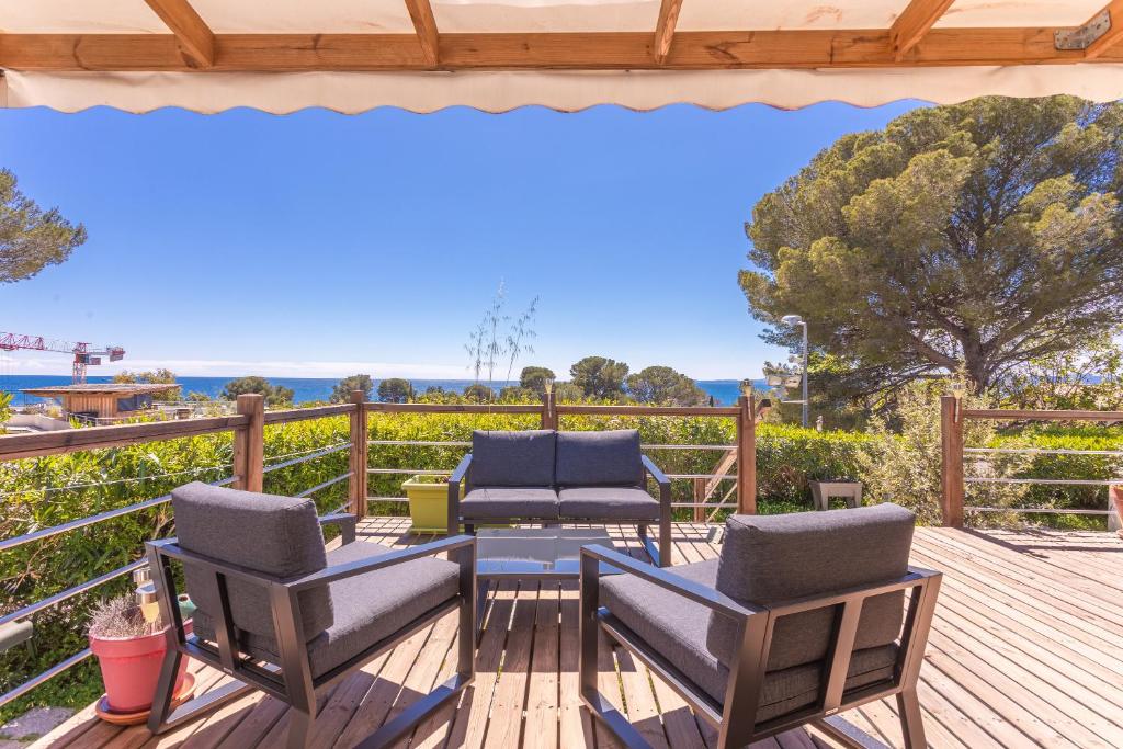 eine Terrasse mit zwei Stühlen und einem Tisch auf einem Deck in der Unterkunft Bungalow V Hugo vue mer terassa in Saint-Raphaël