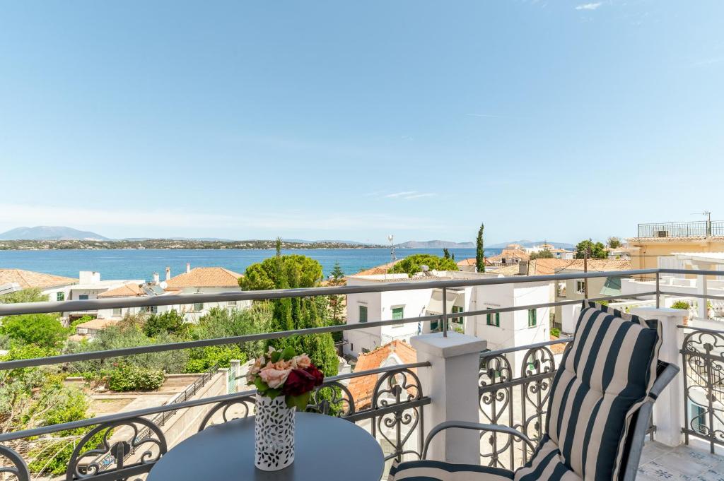 a balcony with a table and chairs and a view of the water at Martha's House in Spetses