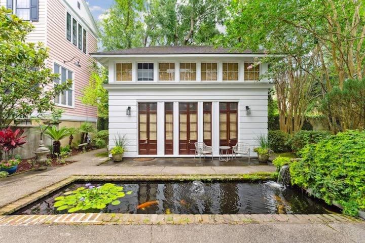 a house with a koi pond in front of a house at Serene Cottage with Beautiful Garden and Heated Pool in Charleston