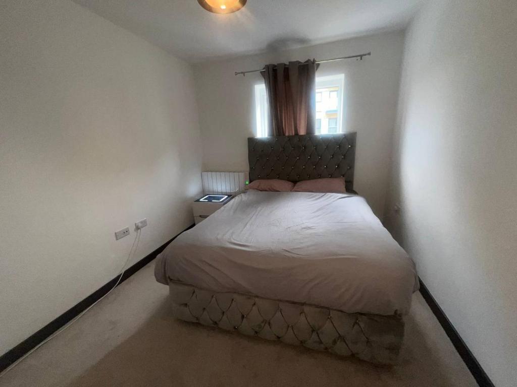 NDO DARTFORD LUXX PRIVATE ENSUITE-ROOM في دارتفورد: غرفة نوم صغيرة مع سرير في غرفة