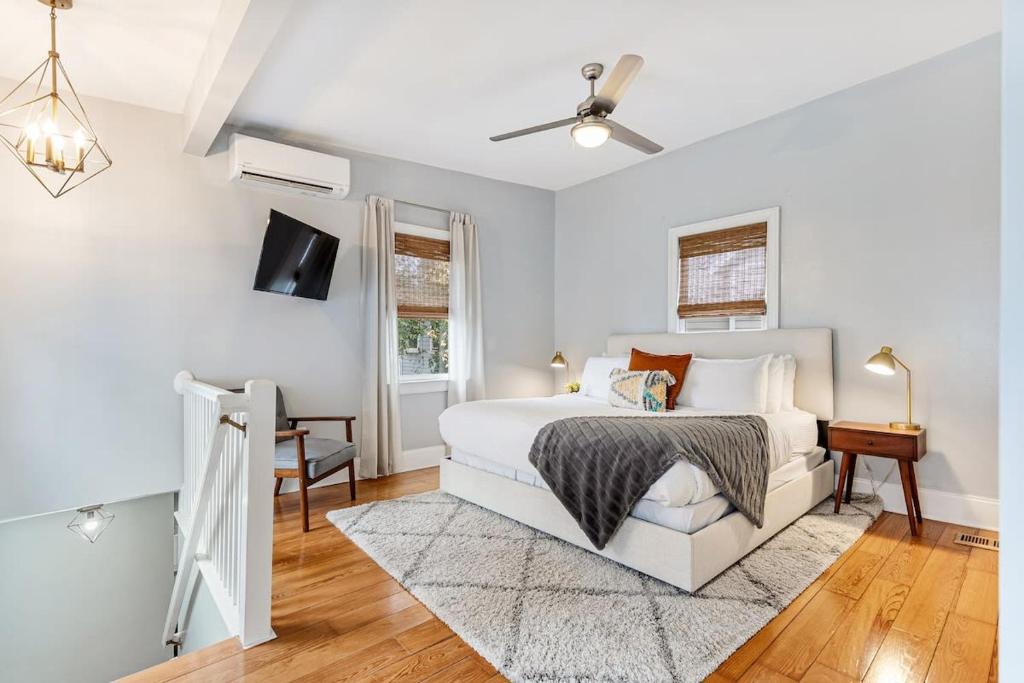 um quarto branco com uma cama e uma televisão em Spacious and Quiet One Block off King Street em Charleston