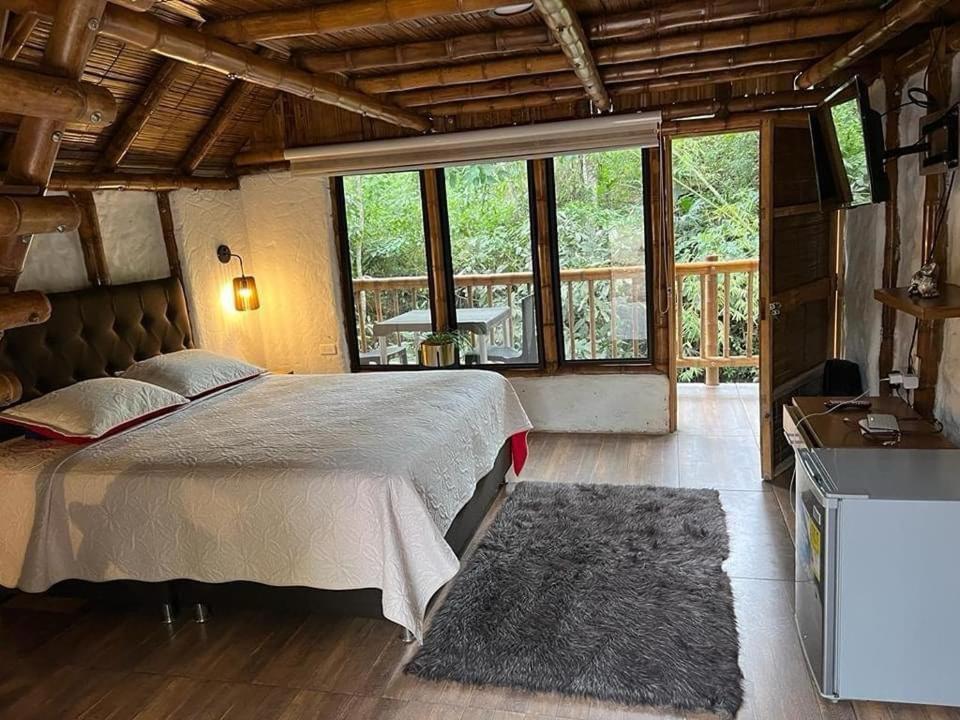 1 dormitorio con cama grande y ventana grande en Cabañas Monteleón Paicol- Huila en La Laja