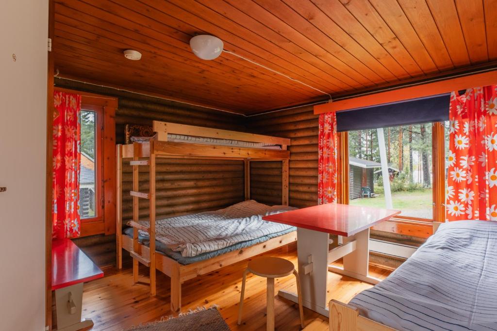 Dormitorio con litera y mesa en una cabaña en Lomakylä Timitraniemi, en Lieksa