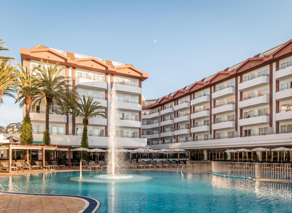 einem Pool mit einem Brunnen vor einem Gebäude in der Unterkunft ALEGRIA Florida Park in Santa Susanna