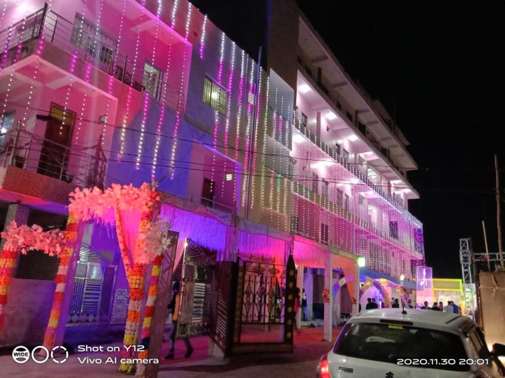 un edificio con luces rosas y moradas. en Hotel Shobha and Tent House, en Patrātu