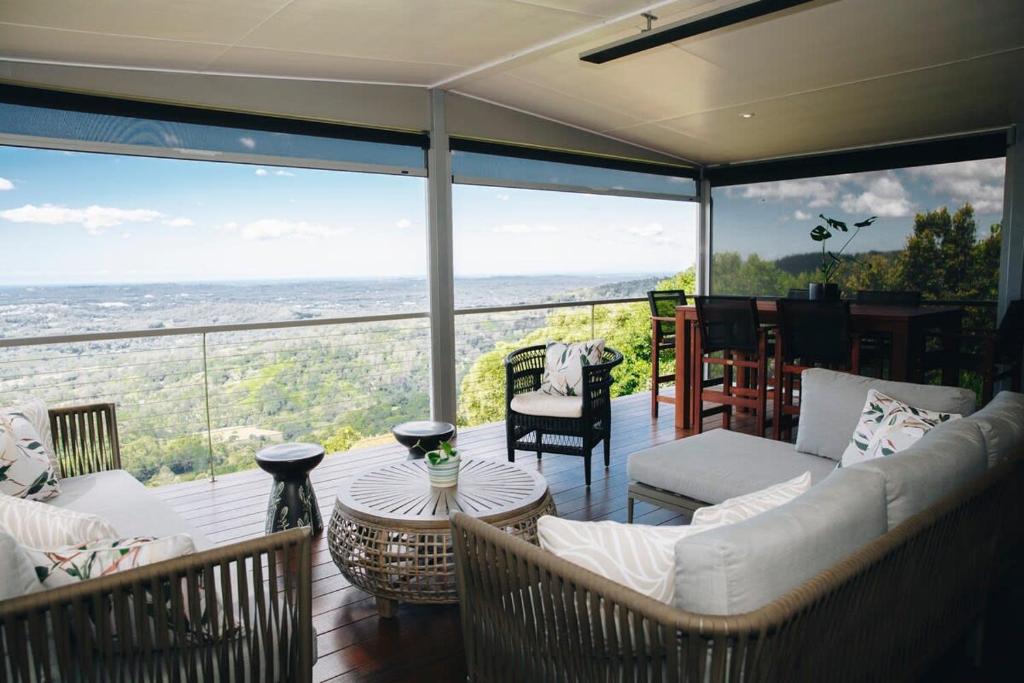 uma sala de estar com um sofá e cadeiras numa varanda em Flaxton residence with spectacular coastal views em Montville