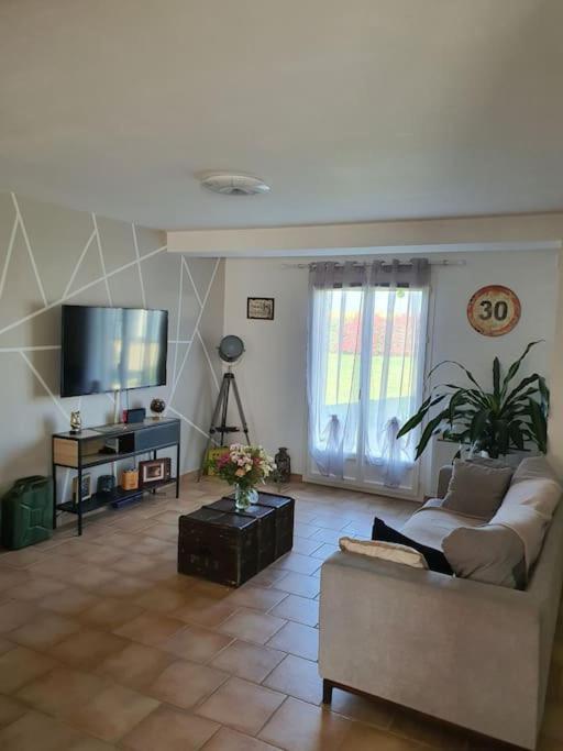 sala de estar con sofá y TV de pantalla plana en maison moderne, en Saint-Antonin-de-Sommaire