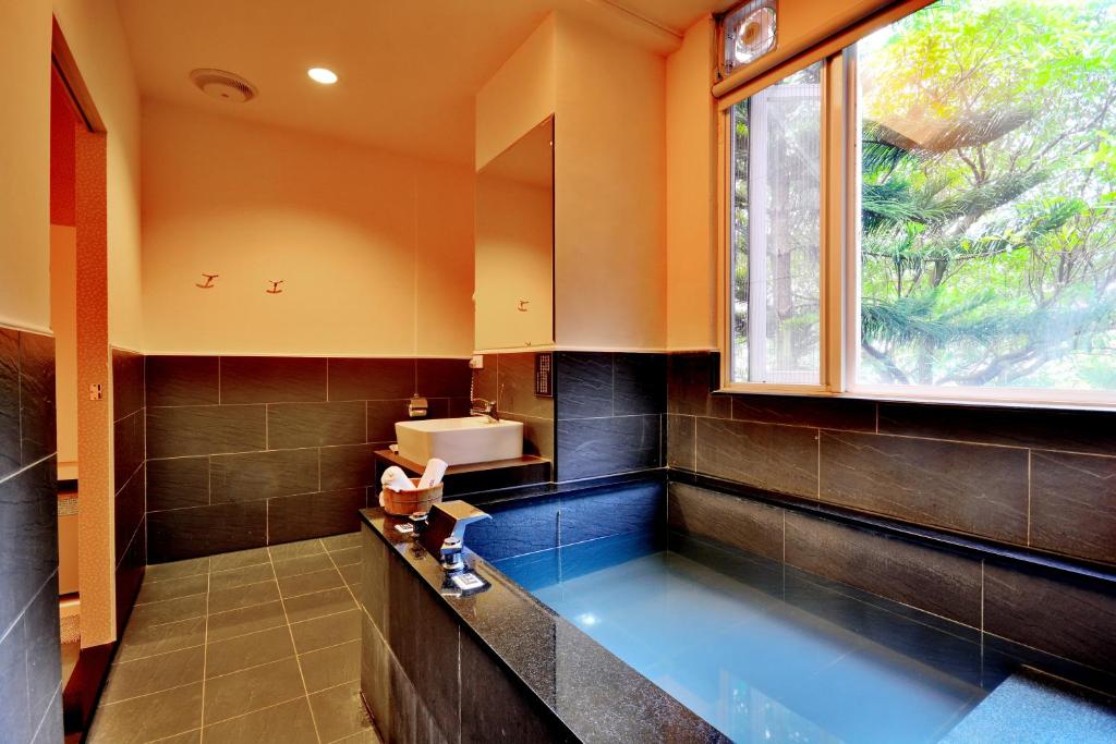 baño con bañera grande y ventana en Courier Station, en Wulai