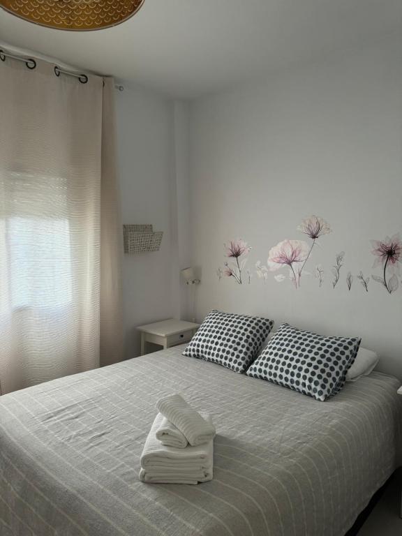 a white bedroom with a bed with two pillows at Son de Mar 1 in Bolonia