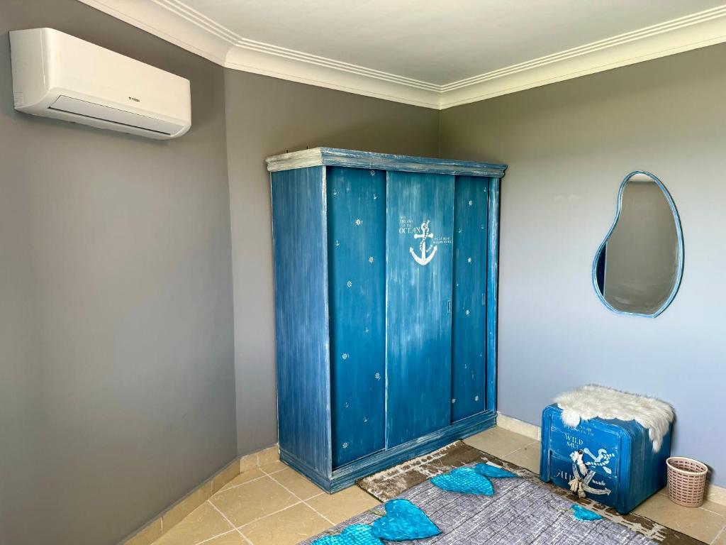 a bathroom with a blue cabinet and a mirror at قرية البوريڤاچ 1 فيلا الصوري جروب in Sarābiyūm