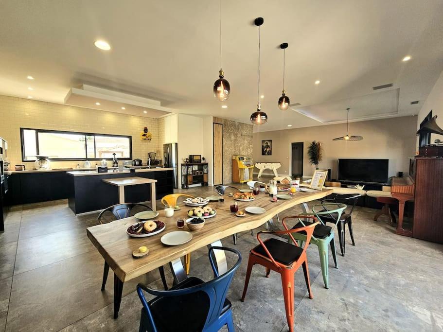 een grote houten tafel en stoelen in de woonkamer bij Le Paradis secret - piscine - clim - pool-house in Garons