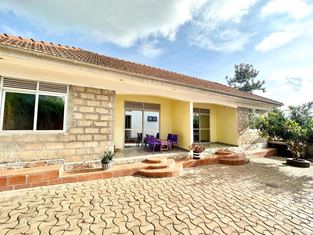 a house with a patio with purple chairs in it at Dangotte Residence Lounge in Kabale