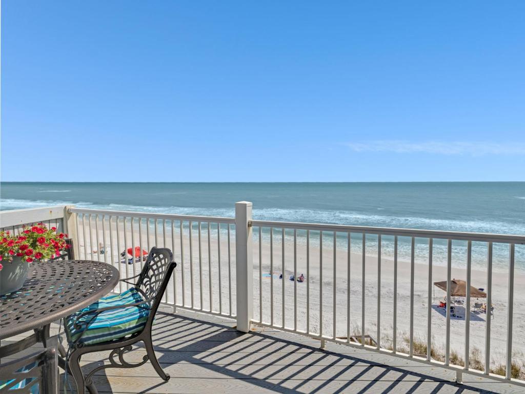 a balcony with a table and chairs and the beach at Seagrove Dunes #1 in Seagrove Beach