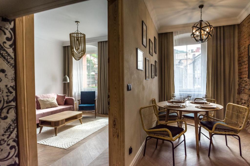 ein Wohnzimmer mit einem Tisch und Stühlen in der Unterkunft Apartamenty Nowa Ruda in Nowa Ruda
