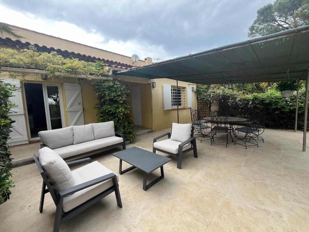 d'une terrasse avec un canapé, des chaises et une table. dans l'établissement Maison à 400 M de la plage de Pampelonne, à Saint-Tropez