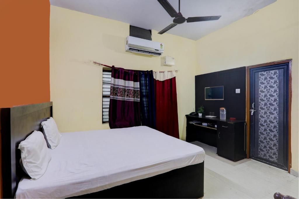 een slaapkamer met een wit bed en een raam bij Suman Niwas in Lucknow