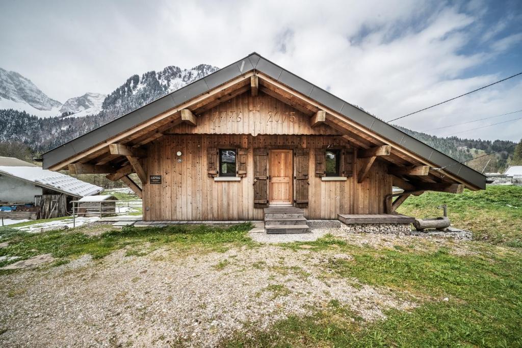 a log cabin with a door in a field at Chalet le Ber Abbay in Abondance