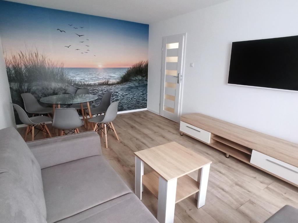 a living room with a tv and a table at Au soleil in Świnoujście