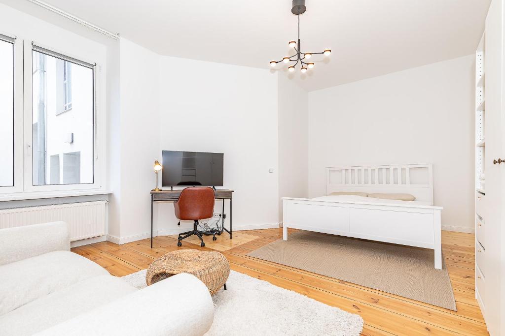 a white living room with a white couch and a desk at Cosy Apartment Berlin Neukölln in Berlin