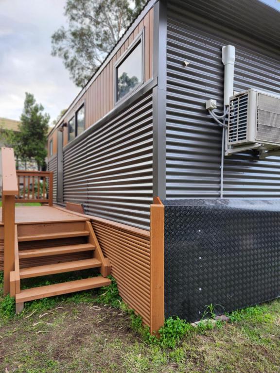 a tiny house with a staircase and a deck at Green heavan in Greenvale
