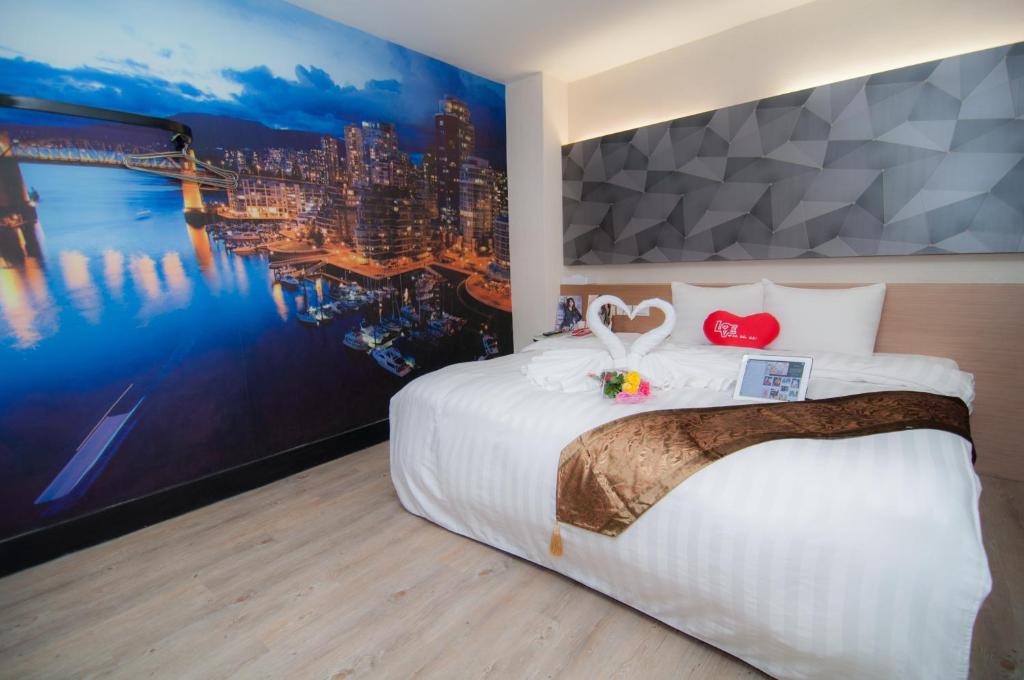 a hotel room with a large bed and a large painting at Hsinchu 101 Inn in Hsinchu City