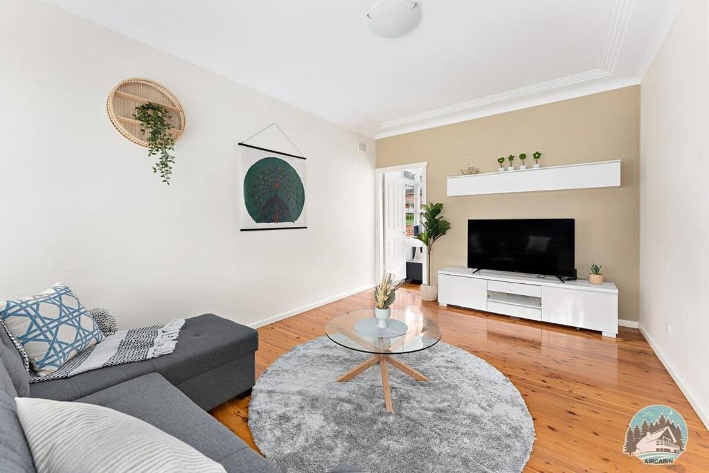 a living room with a couch and a tv at Aircabin - North Ryde - Sydney - 4 Beds House in Sydney