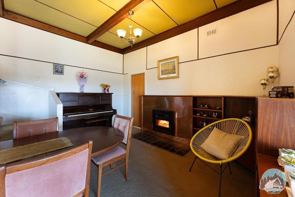 uma sala de estar com uma mesa e uma lareira em Aircabin - Oberon - Great Location - Comfy Chalet em Oberon