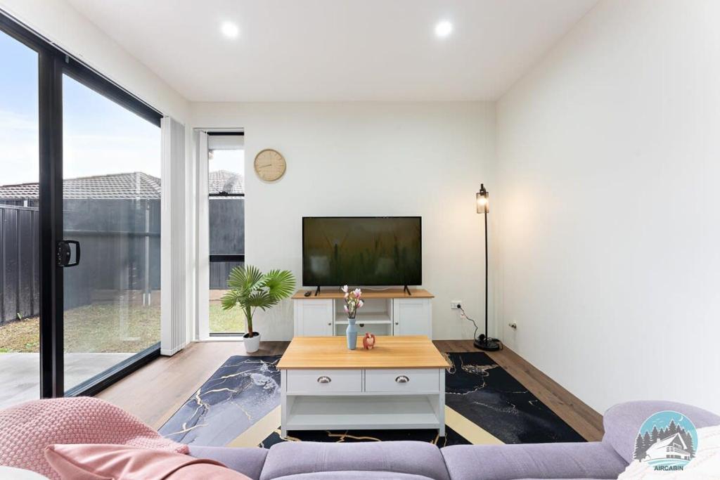 a living room with a couch and a tv at Aircabin - Kingswood - Sydney - 3 Beds Townhouse in Kingswood