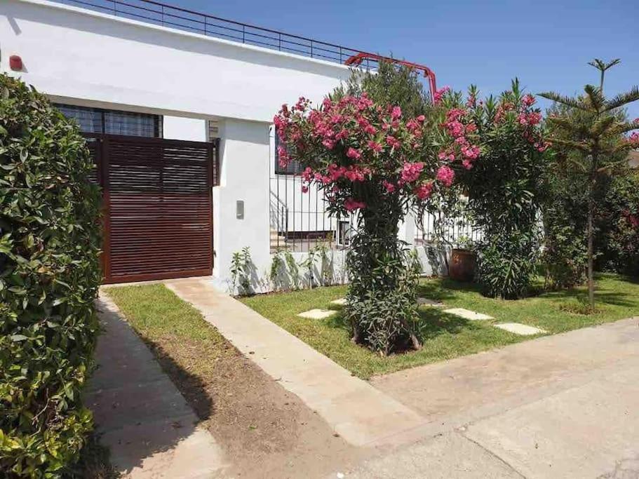 una casa con fiori rosa nel cortile di Villa Havre De Paix à Casablanca a Casablanca