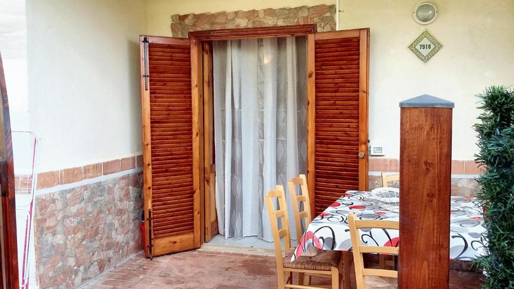 a room with a wooden door and a table and chairs at Studio with shared pool terrace and wifi at Sciacca in Sciacca