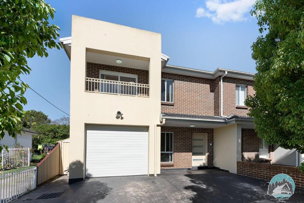 a brick house with a white garage at Aircabin - Panania - Sydney - Cozy - 5 Beds House in Panania