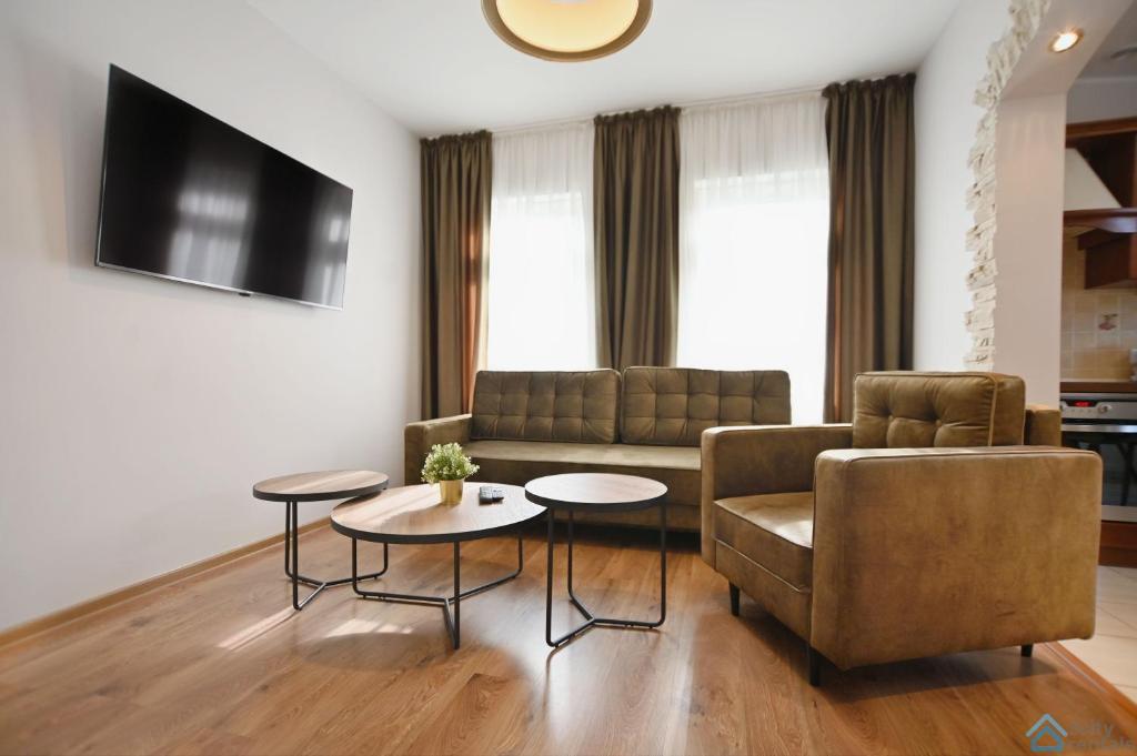 a living room with a couch and a chair and tables at Apartament Chopin in Sopot