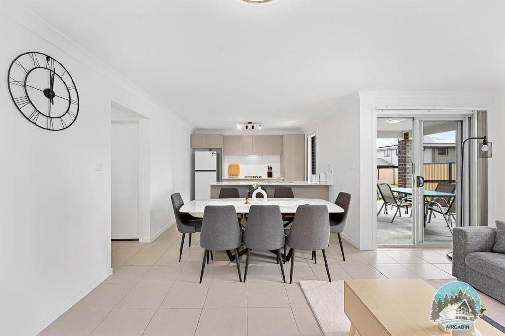 una sala da pranzo e un soggiorno con tavolo e sedie di Aircabin - Edmondson Park - 4 Beds Compy House a Prestons