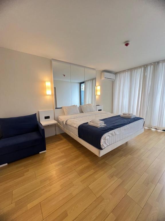 1 dormitorio con 1 cama grande y 1 sofá en Orbi City Hotel, en Batumi