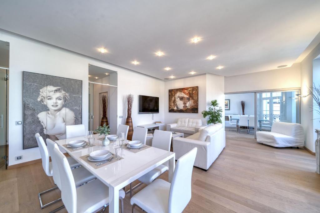 - une salle à manger et un salon avec une table et des chaises blanches dans l'établissement Appartement Francis F. Copolla, à Cannes