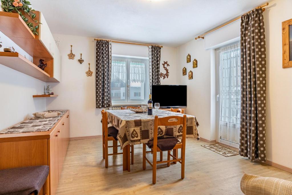House Cuel Milena Folgaria - Yellow في فولاريا: مطبخ وغرفة طعام مع طاولة وكراسي