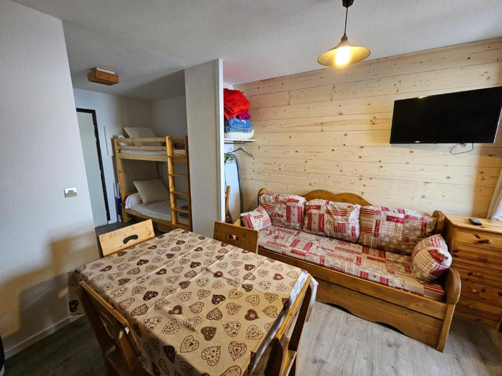 a room with a bed and a couch and a tv at La Croix du Sud in Valmeinier