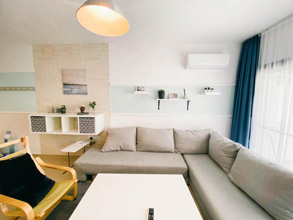 a living room with a couch and a table at Stunning 2 Bedroom Holiday Home in 5-Star Resort in Trikomo