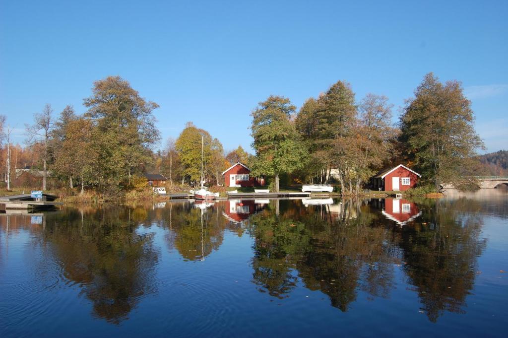 Blick auf einen See mit Häusern und Bäumen in der Unterkunft Kanalvillan in Dals Långed