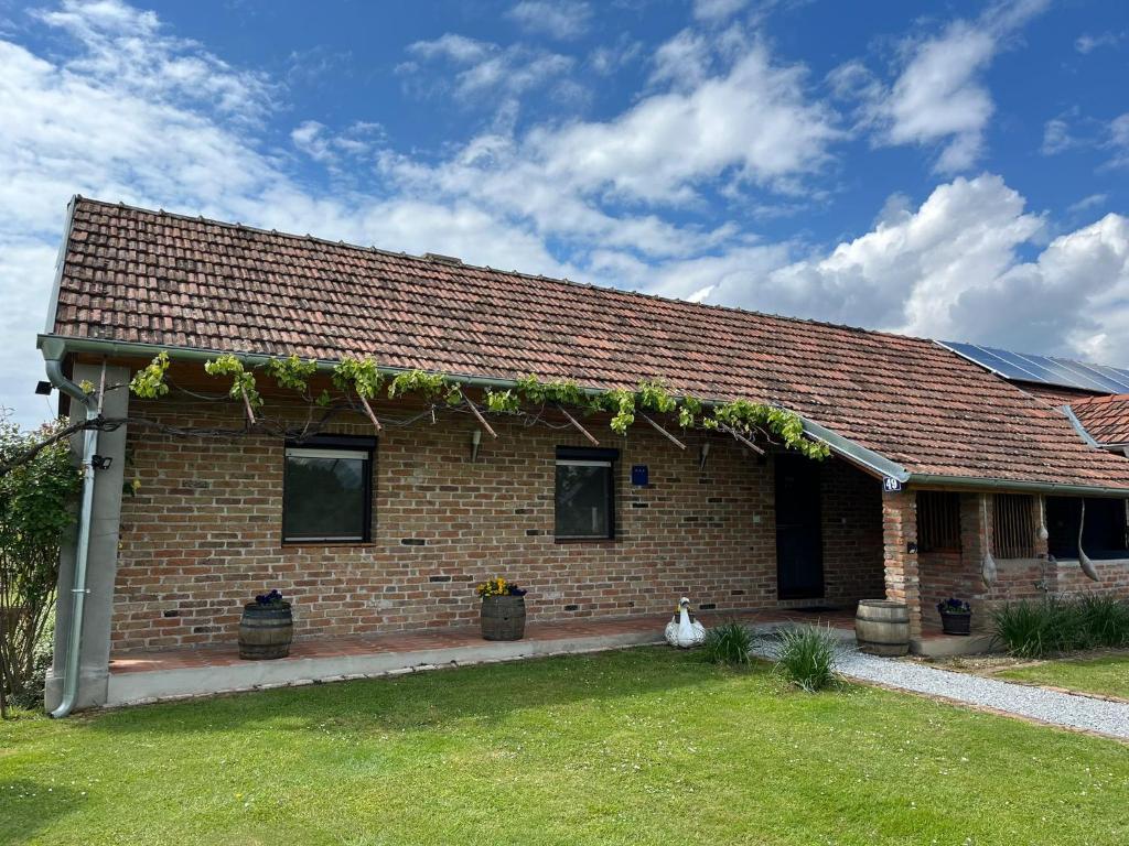 a brick house with vines on the side of it at Kuća za odmor Balog in Lipik