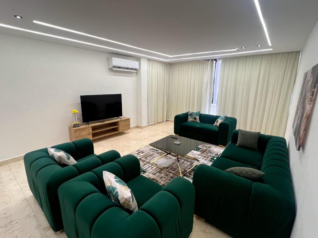 uma sala de estar com dois sofás verdes e uma televisão em New amazing flat front of citystars mall no Cairo