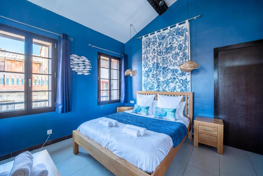 niebieska sypialnia z łóżkiem z niebieskimi ścianami w obiekcie Suites Coronell d'En Vila w Perpignanie