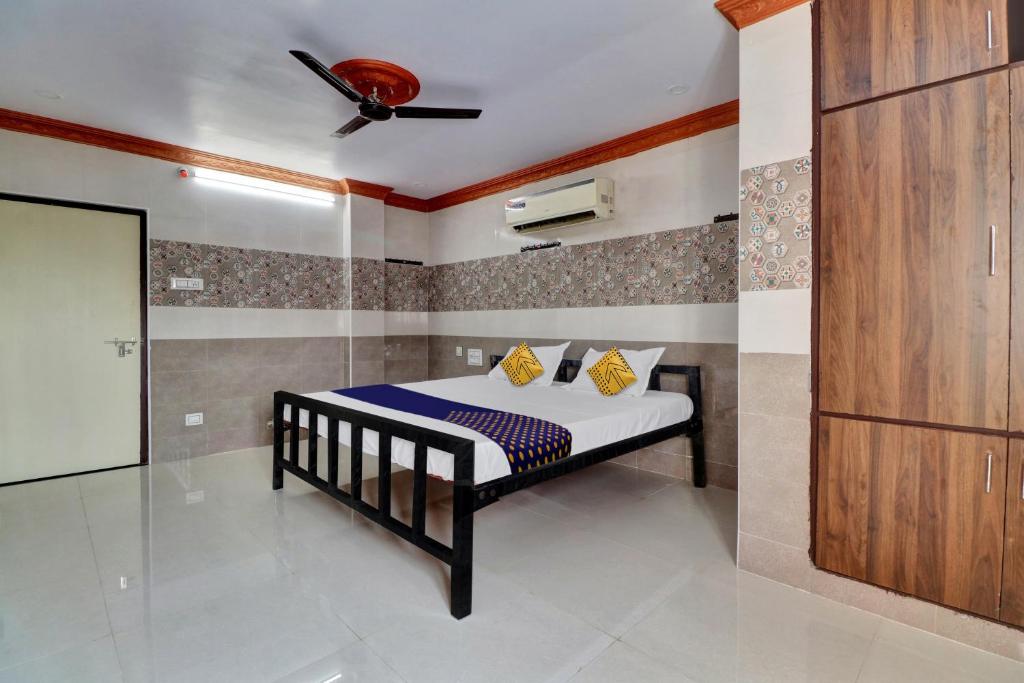 a bedroom with a bed with a ceiling fan at SPOT ON Hotel Maha Lakshmi in Ongole