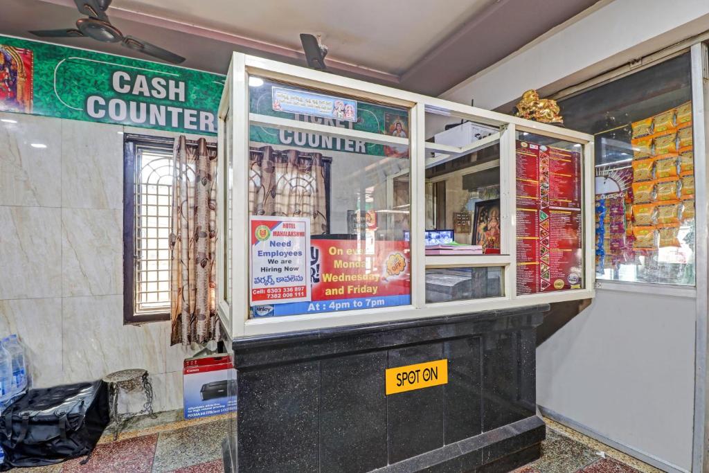 a cash counter with a yellow sign in front of it at SPOT ON Hotel Maha Lakshmi in Ongole
