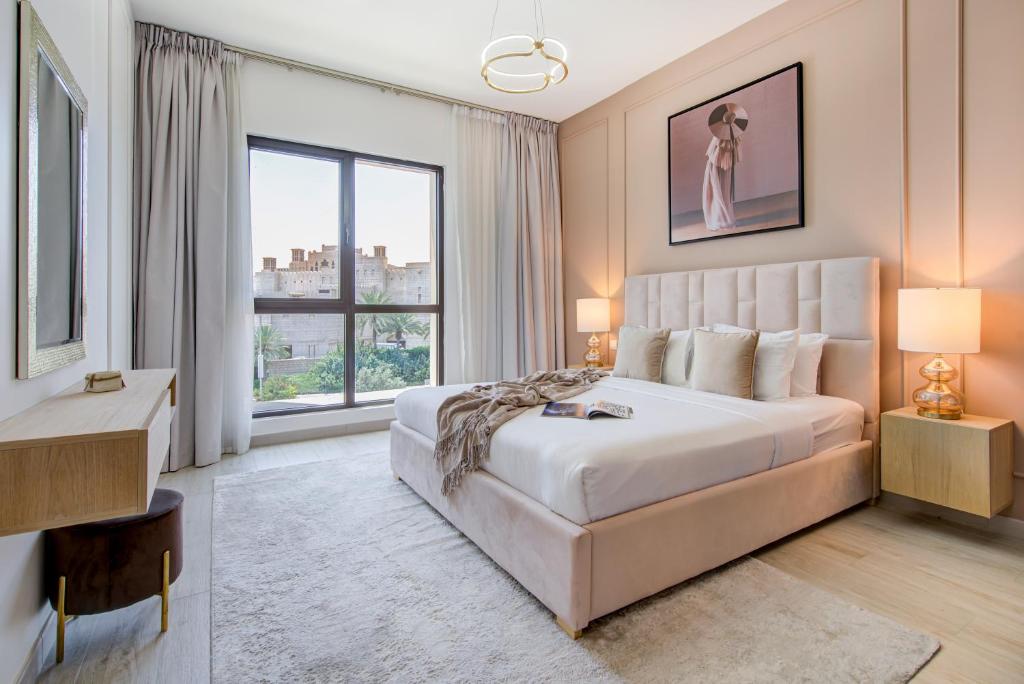a bedroom with a large bed and a large window at Trophy - Burj Al Arad Maison de Reve in Dubai