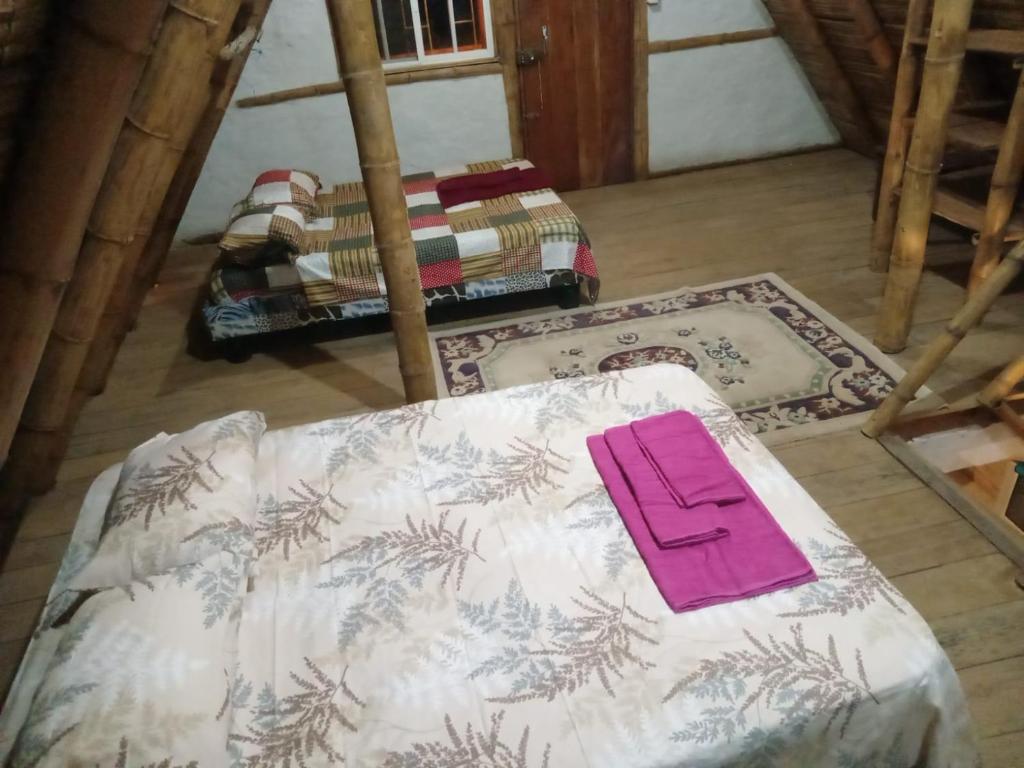 Una habitación con una cama con una servilleta rosa. en Casa completa en Puerto Cayo en Puerto Cayo